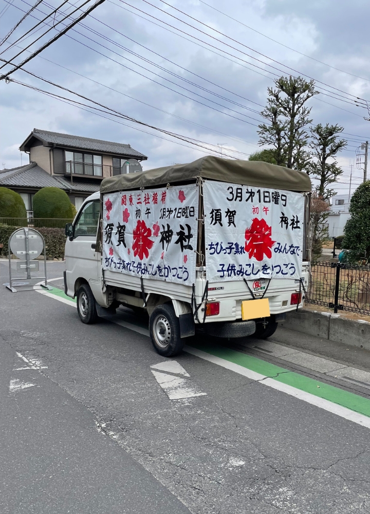 初午大祭の子どもみこしを先導する軽トラック